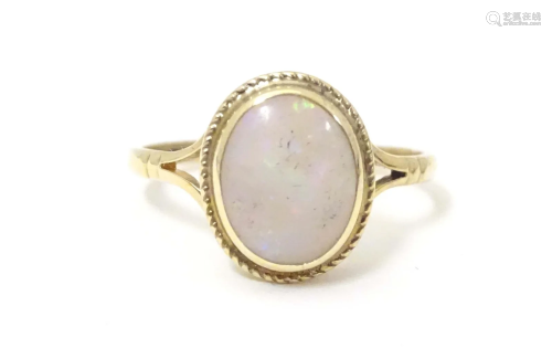 A 9ct gold ring set with central opal cabochon. Ring size ap...
