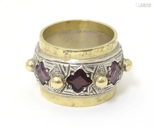 A silver dress ring with gilt detail, set with amethysts and...