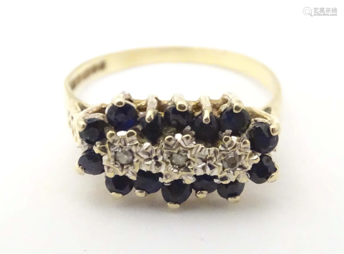 A 9ct gold ring set with diamonds and blue spinels. Ring siz...