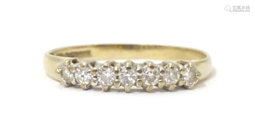 A 9ct gold ring set with seven diamonds in a linear setting....