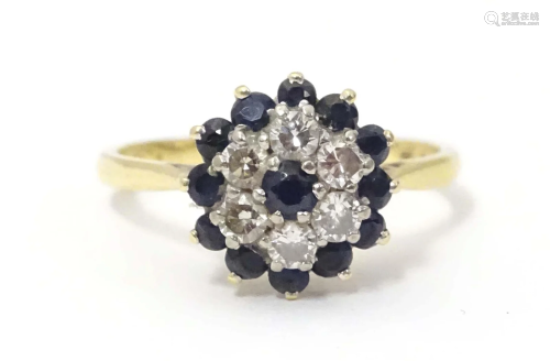An 18ct gold ring set with diamonds and sapphires in a clust...