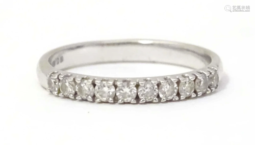 A 9ct white gold ring set with 10 diamonds in a linear setti...