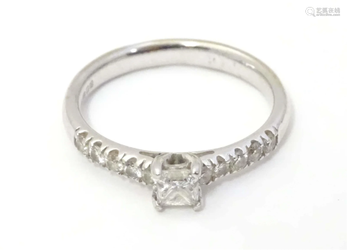 A 9ct white gold ring set with central diamond flanked by 5 ...