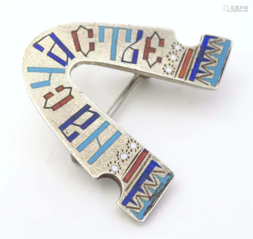 A Russian silver brooch with enamel detail formed as a styli...