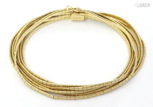 An 18ct gold bracelet formed of seven strands. Marked 750. A...