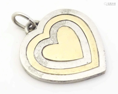A silver pendant of heart form, hallmarked London 1978, make...