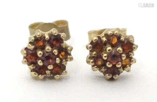 9ct gold stud earrings set with red stone clusters.