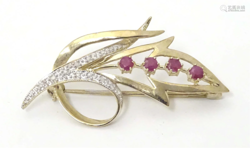 A 9ct gold brooch of floral form set with rubies and diamond...