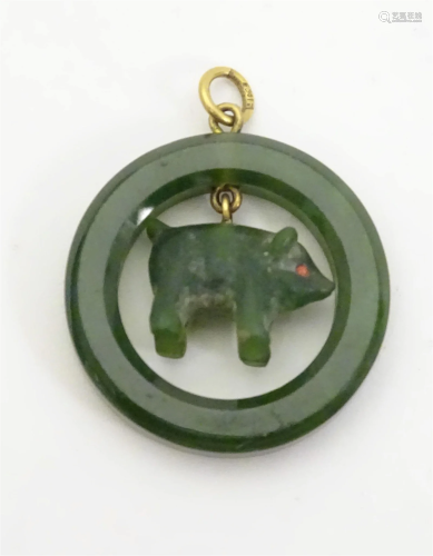 A green hardstone pendant of circular form with pig formed c...