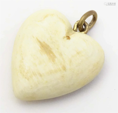 A carved bovine horn pendant of heart form. Approx 1 1/4&quo...