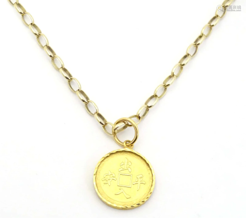 A 9ct gold chain with pendant formed an Oriental coin in cap...