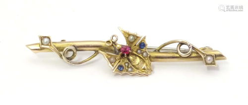 A 9ct gold bar brooch with butterfly decoration to centre se...