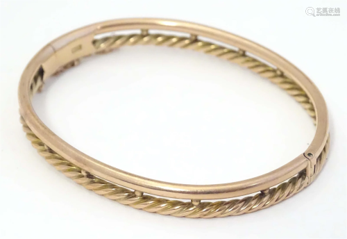 A 9ct gold bracelet of bangle form with rope twist detail