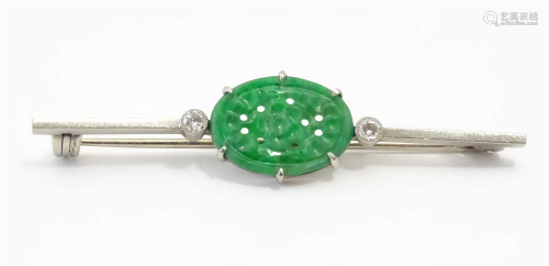 An 18ct white gold brooch set with central carved jade oval ...