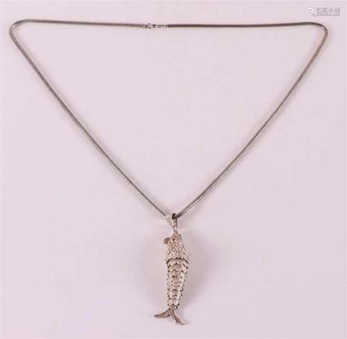 A silver snake necklace on a flexible fish pendant.