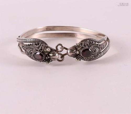 A 1st grade silver rigid bracelet with dragon heads and garn...