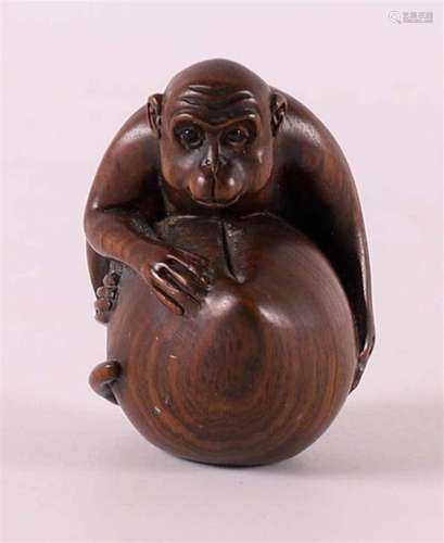 A tropical wooden netsuké of a monkey on a nut, Japan, 20th ...