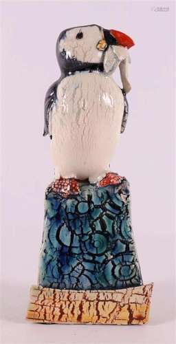 A polychrome porcelain puffin on a rock.