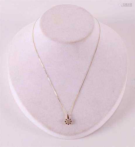 A 14 kt gold necklace on a gold pendant, set with a diamond.