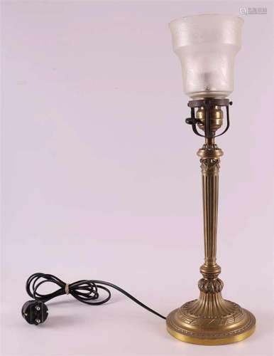 A brass table lamp base with satin glass shade, around 1900.