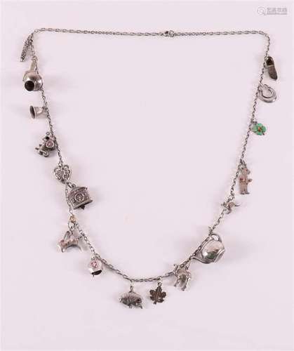 A 2nd grade silver anchor necklace with many charms.