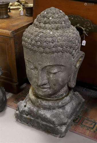 A concrete garden sculpture of a bust of Buddha on a loose p...