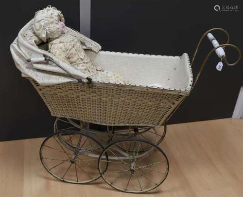 A doll carriage with a doll in it, around 1900.