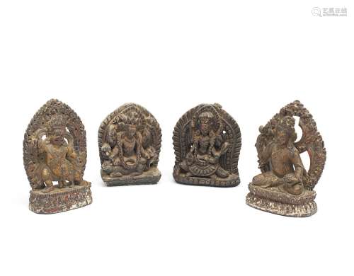 FOUR WOOD CARVINGS OF GUARDIANS AND DEITIES Tibet and Nepal,...