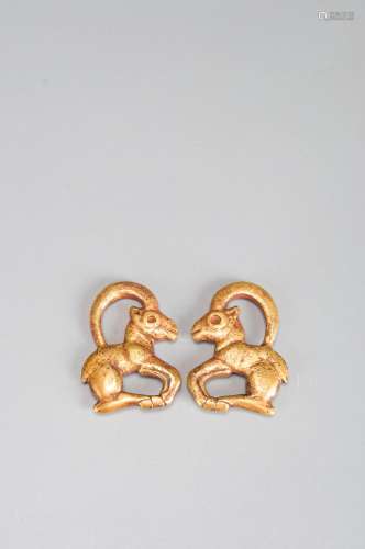 A pair of gold goat ornaments