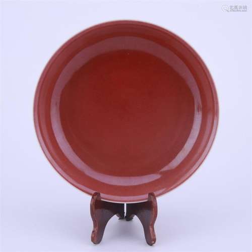 A red glazed porcelain plate