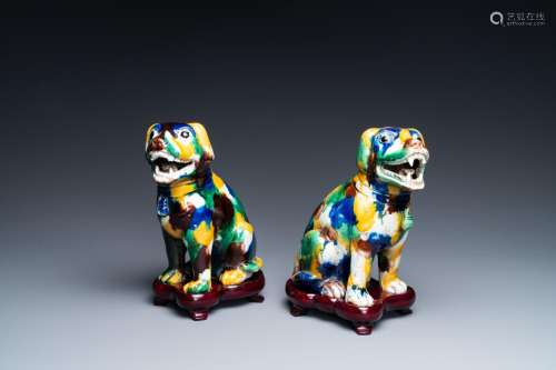 A pair of Chinese sancai-glazed dogs on wooden stands, 19th ...