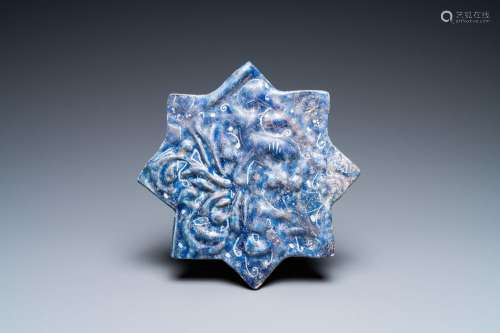 A molded Ilkhanid Lajvardina blue-ground star-shaped tile, I...