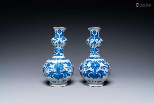 A pair of Dutch Delft blue and white 'garlic head' vases wit...