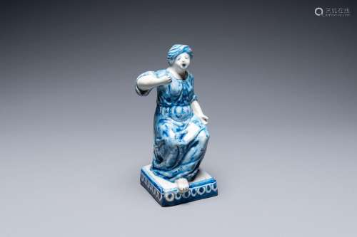 A Dutch Delft blue and white figure of a seated lady, 18th C...