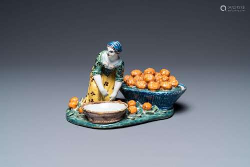 A polychrome Dutch Delft figure of a fruit seller with a sma...