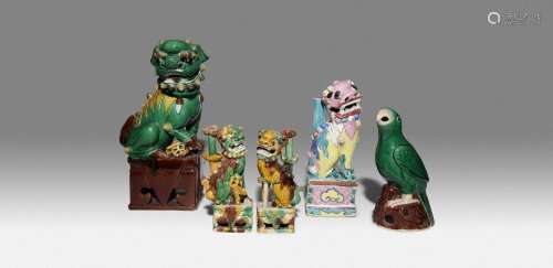 FOUR CHINESE FIGURES OF LION DOGS AND A MODEL OF A PARROT