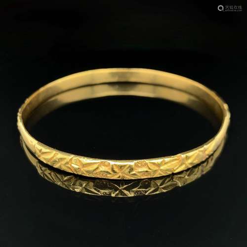 BRACELET rigide ouvrant en or jaune (750‰) ciselé à motifs d...