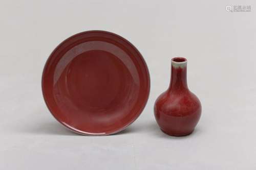 A CHINESE COPPER RED-GLAZED BOTTLE VASE AND DISH. The ovoid ...