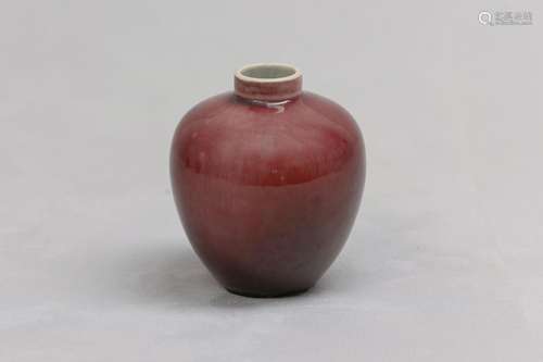 A CHINESE RED-GLAZED JAR. Qing Dynasty. The ovoid body risin...