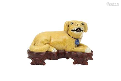 A CHINESE YELLOW-GLAZED MODEL OF A RECUMBENT DOG. Qing Dynas...