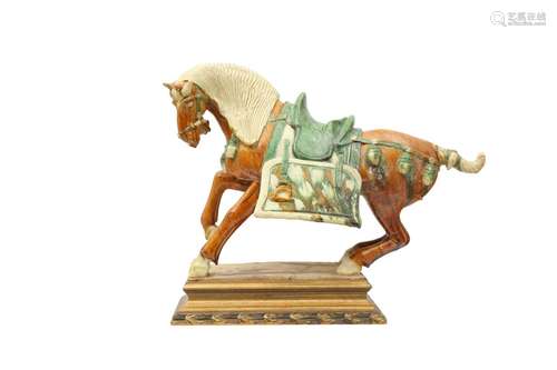 A CHINESE SANCAI-GLAZED MODEL OF A HORSE. Standing in a dyna...