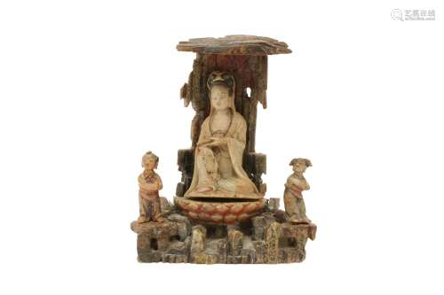 A CHINESE SOAPSTONE CARVING OF A GUANYIN IN A GROTTO WITH TW...