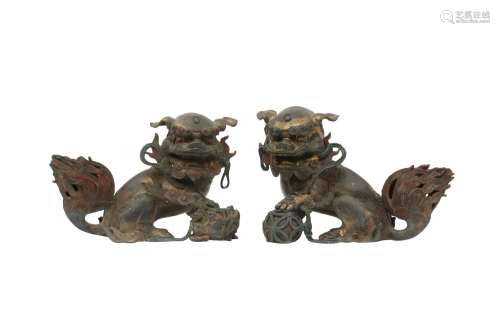 A PAIR OF CHINESE GILT-BRONZE LION DOGS. Cast seated on thei...