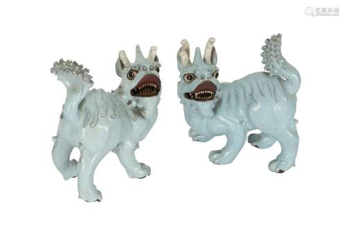 A PAIR OF CHINESE PALE BLUE GLAZED MODELS OF MYTHICAL BEASTS...