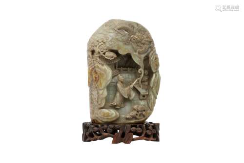 A CHINESE PALE CELADON BOULDER. Carved with a figure on a te...