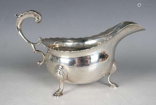 A George V silver sauceboat with hammered finish and foliate...