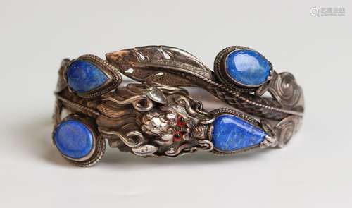 An Asian silver and lapis lazuli oval hinged bangle in the f...