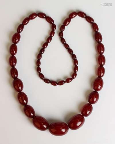 A single row necklace of graduated cherry coloured oval reco...