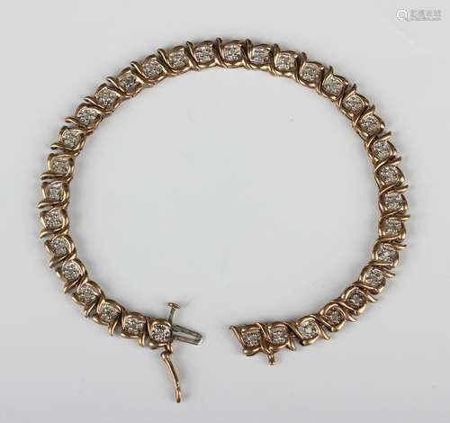 A 9ct gold and diamond bracelet in a serpentine link design