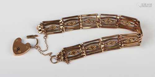 A gold bar and decorated link gate bracelet